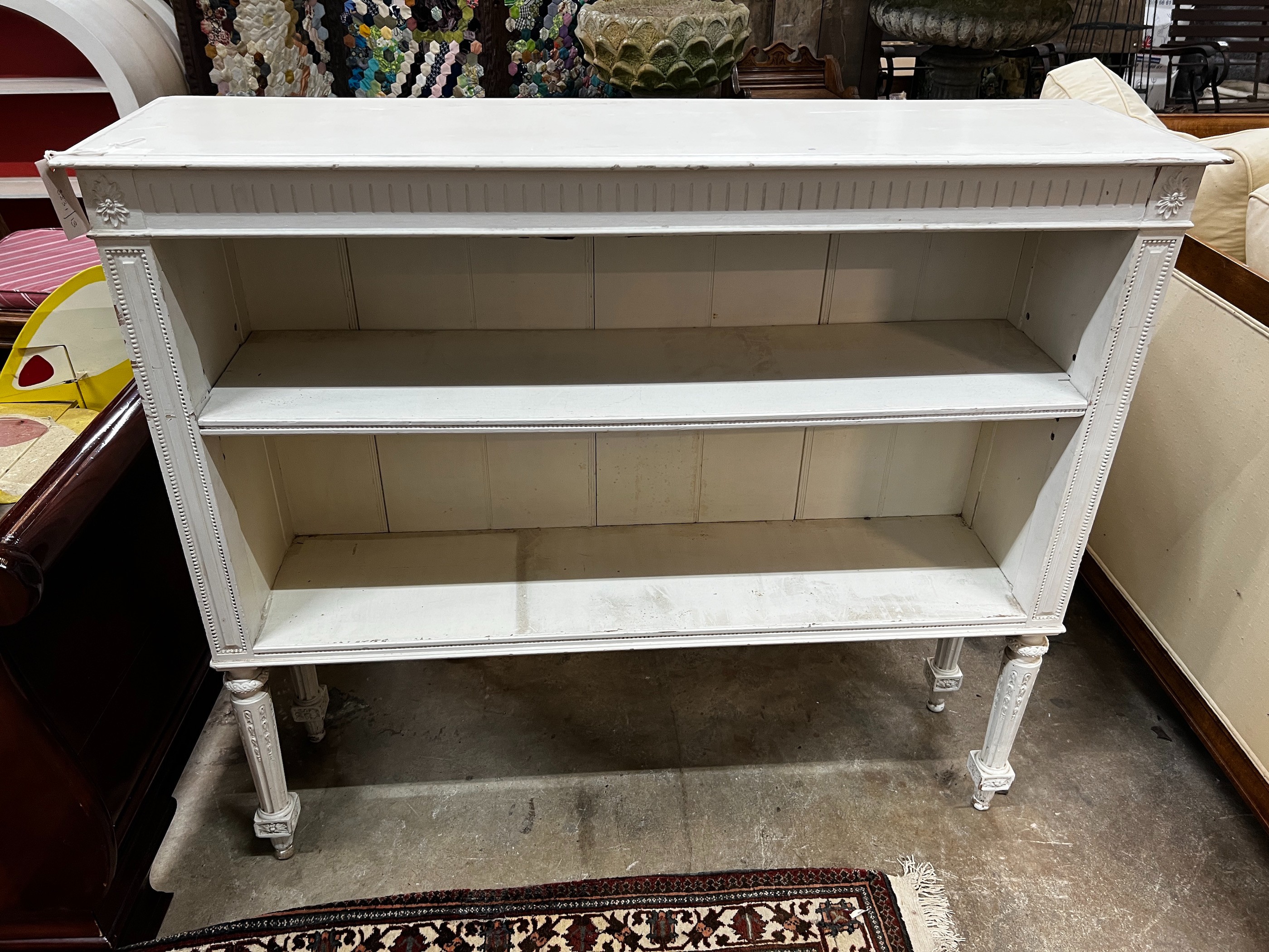 An early 20th century French painted open bookcase, length 110cm, depth 29cm, height 96cm